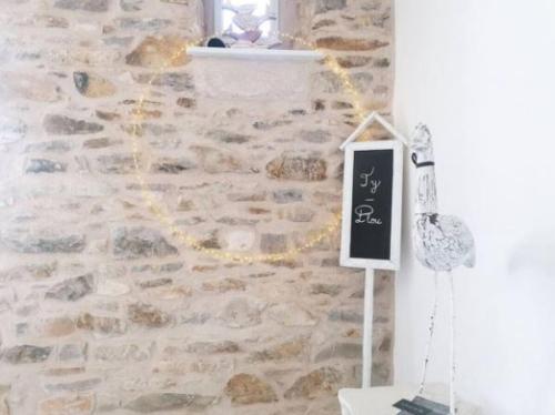 a stone wall with a chalkboard sign on it at Ty Plou in Ploubazlanec