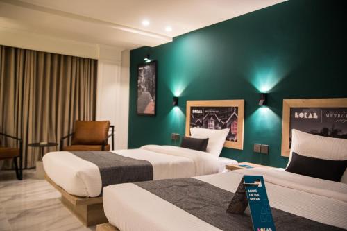 a hotel room with two beds and a green wall at Metropole Hotel in Murree