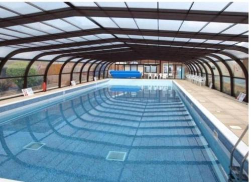 a large swimming pool with an open structure at Waterside Villa in Corton