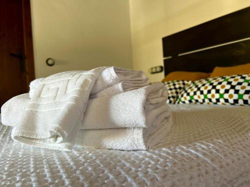 a pile of towels sitting on a bed at Casa La Retama - Pequeño Rocio in El Rocío
