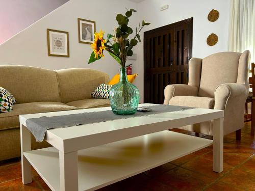 a white coffee table with a vase on top of it at Casa La Retama - Pequeño Rocio in El Rocío