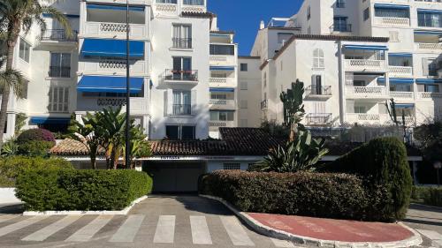 vistas a un edificio con árboles y arbustos en Playa Del Duque Apartment Ocean Club 1, en Marbella