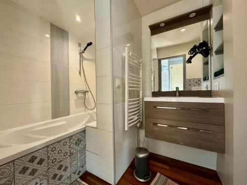 een badkamer met een bad, een wastafel en een spiegel bij Appartement charmant hyper centre ville Rouen in Rouen