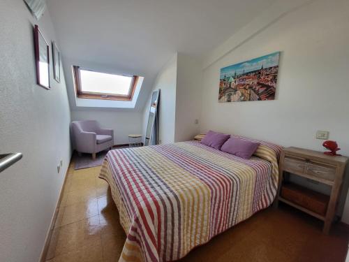 1 dormitorio con 1 cama con almohadas moradas en APART PL DO PAZO - Sanxenxo, en Sanxenxo