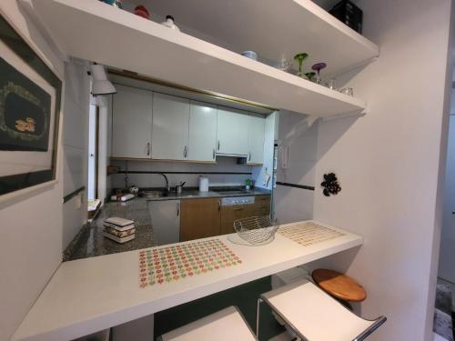 uma pequena cozinha com armários brancos e um balcão em APART PL DO PAZO - Sanxenxo em Sanxenxo