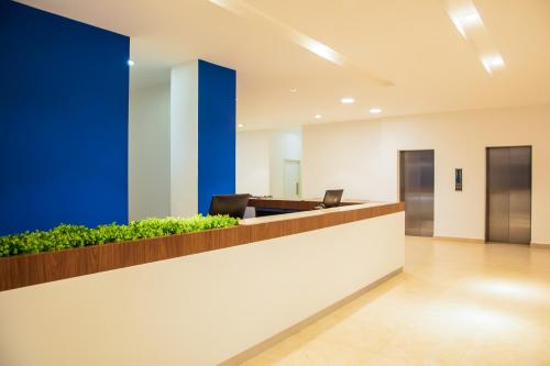 un vestíbulo de oficina con una pared de acento azul en One Irapuato en Irapuato