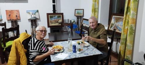two older people sitting at a table eating food at Paisagem do Guadiana Turismo Rural in Odeleite