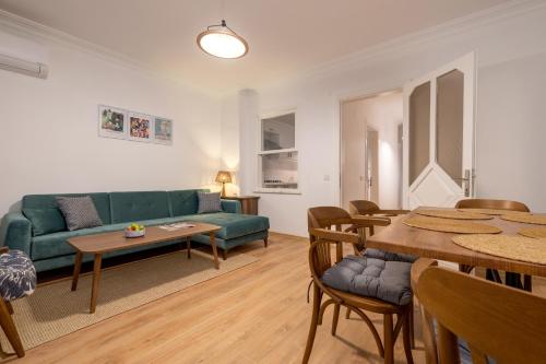 a living room with a green couch and a table at Gurel Garden House in Kucukkuyu