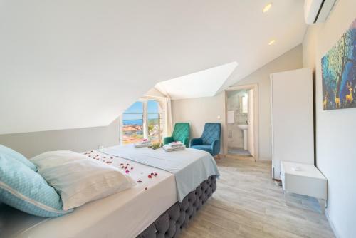 sypialnia z dużym łóżkiem i 2 niebieskimi krzesłami w obiekcie Stunning Suite in Ölüdeniz with Seaview And Pool w Ölüdeniz