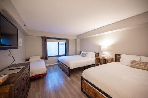 a hotel room with two beds and a flat screen tv at Stay Together Suites on The Strip - 2 Bedroom Suite 976 in Las Vegas