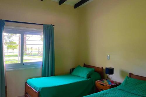 1 dormitorio con 2 camas y ventana en Casa en Tupungato en Tupungato