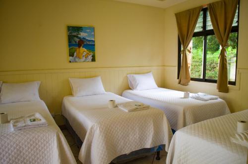 a room with three beds and a picture on the wall at Hotel Casa Ki'iil, San Juan La Laguna,Sololá, Guatemala in San Juan La Laguna