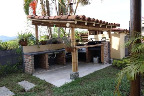 an outdoor grill with a roof on top at Villas Panaca Portal 1 in Quimbaya