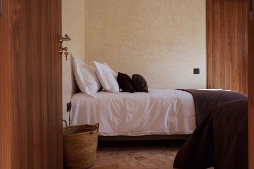 a bedroom with a bed with white sheets and pillows at Loued Surf Lodge in Imsouane