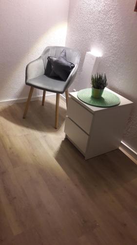 uma cadeira sentada ao lado de uma mesa num quarto em Familie Vietzke em Hanôver