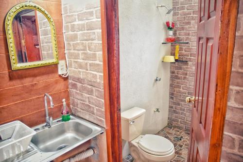 een kleine badkamer met een wastafel en een toilet bij Cabaña/bungalow a orillas de Laguna. vacacional in Catazajá