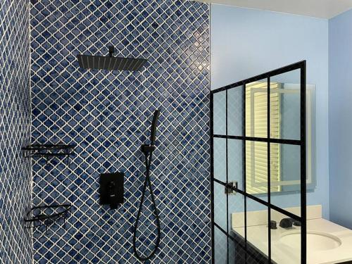 a blue tiled bathroom with a glass shower backdoor at Home with Free Tesla Charger in Christiana in Newark