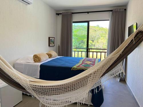 a hammock in a bedroom with a balcony at Pousada do lago in Guaramiranga
