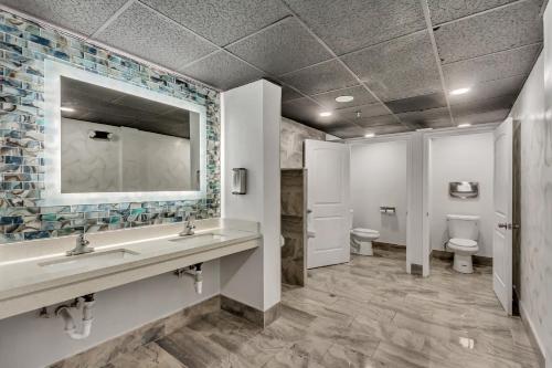 a bathroom with two sinks and two toilets at Clarion Inn Salt Lake City Airport in Salt Lake City