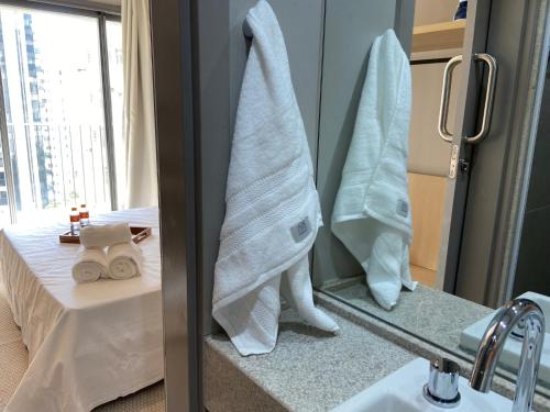 a bathroom with towels hanging on a wall next to a sink at Studio Completo na Haddock Lobo in São Paulo
