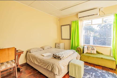 a bedroom with a bed and a window with green curtains at Juraya guest house in Pretoria