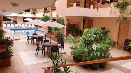 um pátio do hotel com mesas e cadeiras e uma piscina em Hotel Costa Miramar Acapulco em Acapulco