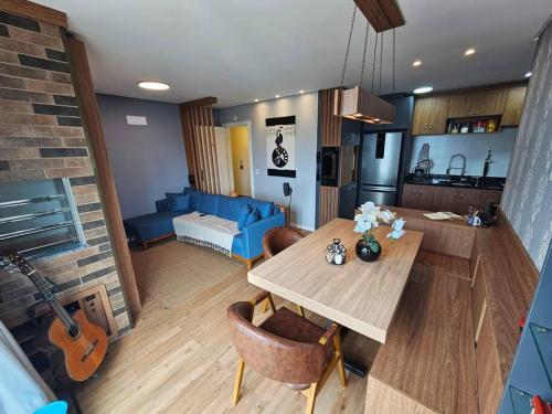 a living room with a table and a room with a couch at Apto Completo Centro Joinville in Joinville