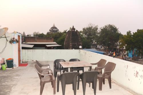 Hostel shivshakti khajuraho في خاجوراهو: طاولة وكراسي على سطح المبنى