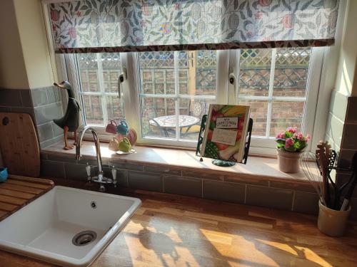d'une fenêtre de cuisine avec un évier et un rebord de fenêtre. dans l'établissement Pretty cottage in the heart of Tenterden, à Kent