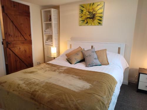 - une chambre avec un grand lit et des oreillers dans l'établissement Pretty cottage in the heart of Tenterden, à Kent