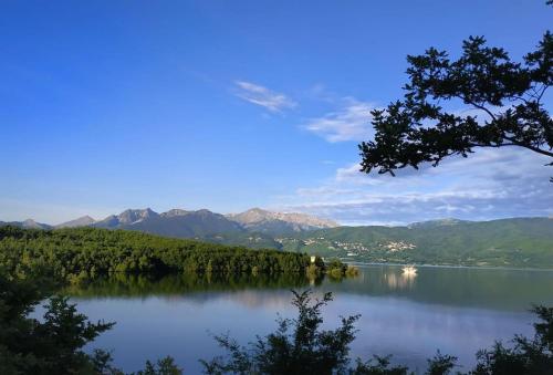 vistas a un lago con montañas en el fondo en Eftychia’s home-Σπίτι με θέα τη λίμνη Πλαστήρα, en Ágios Athanásios