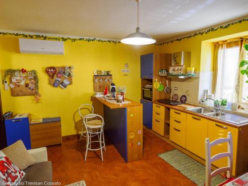 kuchnia z żółtymi ścianami, zlewem i blatem w obiekcie Casadinonnabella w mieście Biella