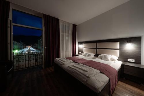 - une chambre avec un grand lit et une fenêtre dans l'établissement Quantum House, à Vatra Dornei