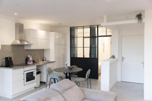 a kitchen and living room with a couch and a table at Grand Loft Industriel avec Vue Cathédrale Centre in Metz