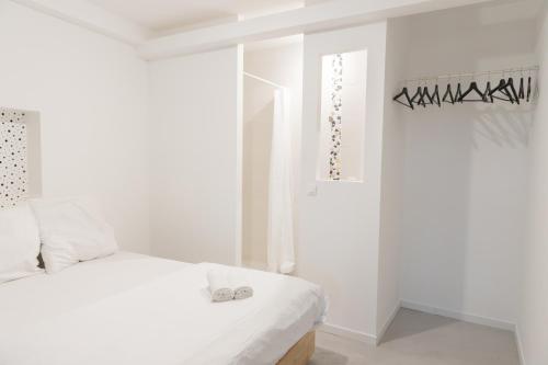 ein weißes Schlafzimmer mit einem Bett mit Schuhen drauf in der Unterkunft Grand Loft Industriel avec Vue Cathédrale Centre in Metz