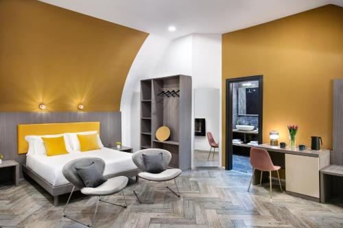 une chambre d'hôtel avec un lit et deux chaises dans l'établissement Residenza Toledo Lifestyle, à Naples
