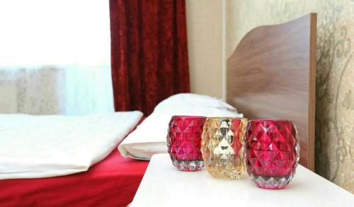 twee glazen op een tafel naast een bed bij VIP apart 364 in Tbilisi City
