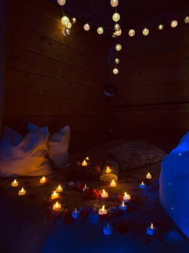 a dark room with candles and lights on a bed at Chambre avec spa privé in Candor