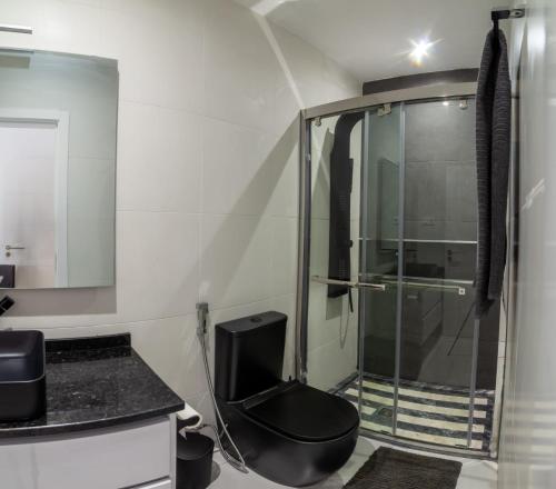 a bathroom with a glass shower and a toilet at Apartamento Berlim in Praia