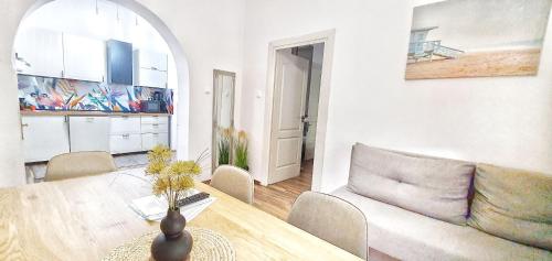 uma sala de estar com uma mesa e um sofá em Dora Holiday House & Apartments em Keszthely