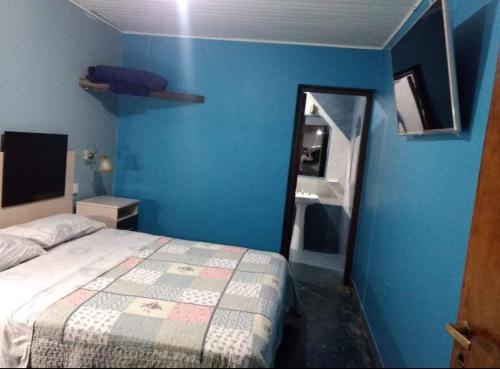 una camera con letto e parete blu di HOSTAL DEL SOL a Manuel Elordi