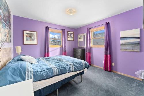 a purple bedroom with a bed and two windows at 3 bedroom duplex by Sanford in Sioux Falls