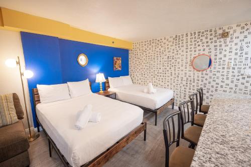 a room with two beds and a table and chairs at Stay Together Suites on The Strip - 1 Bedroom Suite 1012 in Las Vegas