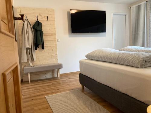 1 dormitorio con 2 camas y TV de pantalla plana en Ferienwohnungen Brugger, en Obermaiselstein