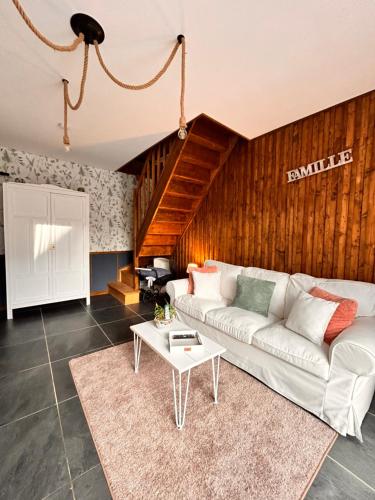 a living room with a white couch and a table at La Grange Aux Hirondelles - Chambre familiale in Woignarue