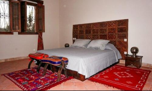 Dar Chenguiti في تارودانت: غرفة نوم مع سرير كبير مع طاولة وسرير سيد