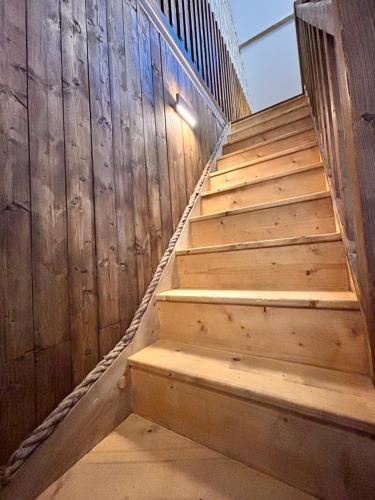 a stairway with a wooden wall and wooden steps at La Grange Aux Hirondelles - Chambre familiale in Woignarue
