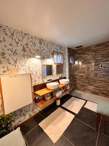 a bathroom with two sinks and a mirror at La Grange Aux Hirondelles - Chambre familiale in Woignarue