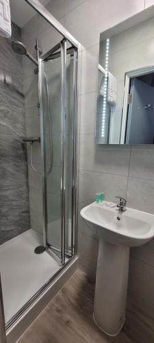 a bathroom with a glass shower and a sink at Sure Hotel by Best Western Reading in Reading