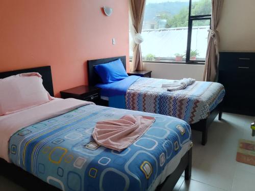 - une chambre avec 2 lits et une fenêtre dans l'établissement Hostal Casa del Valle, 